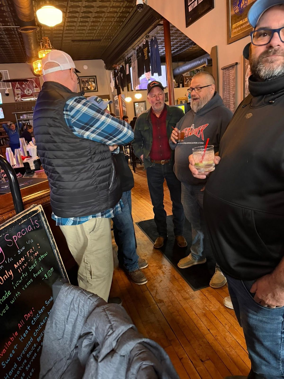 Charter captains and recreational fishermen in conversation in a warm wood-panelled interior