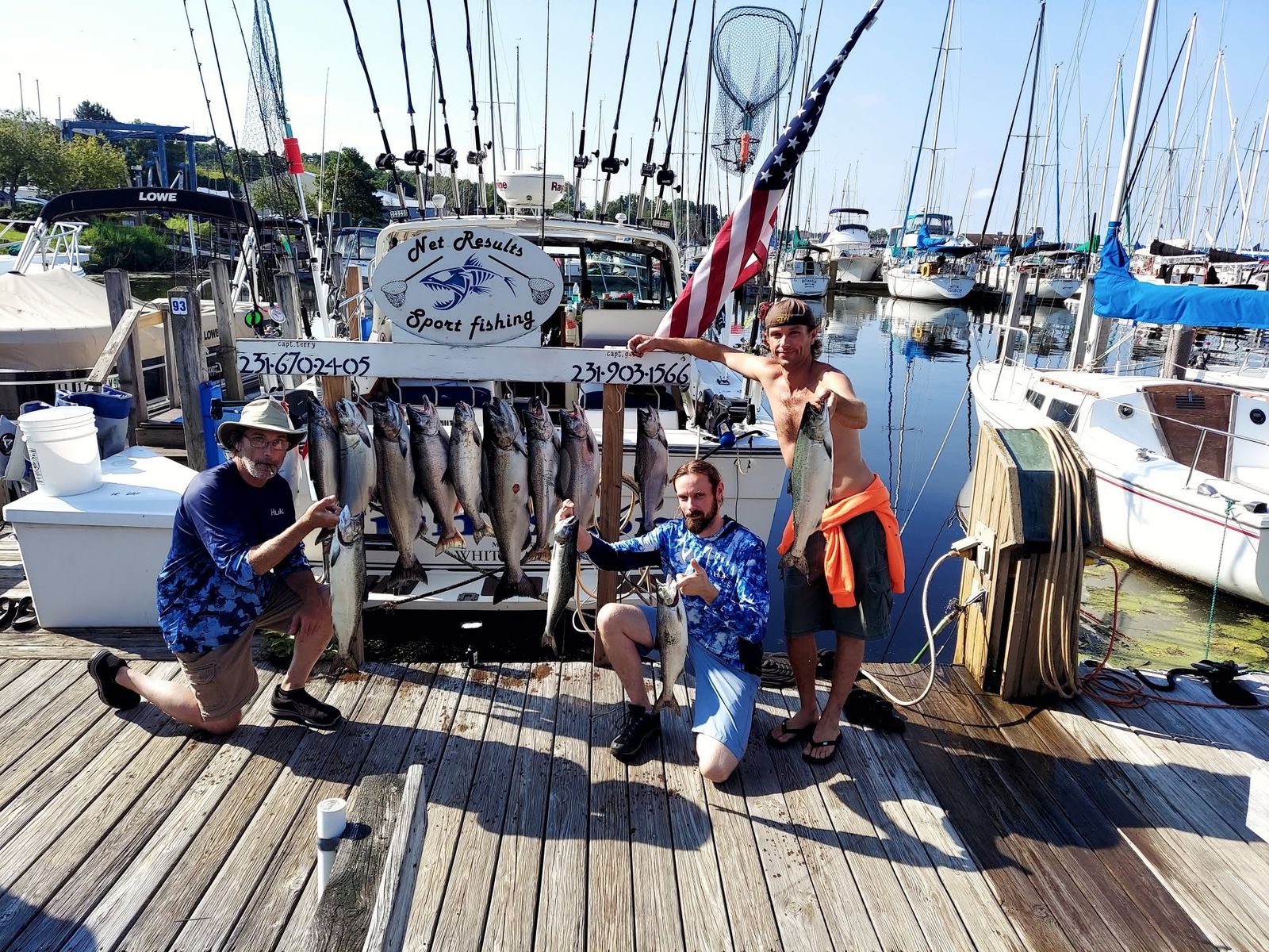 Crew of the Net Results Sport Fishing charter boat with a morning's catch on the dock at the Muskegon marina