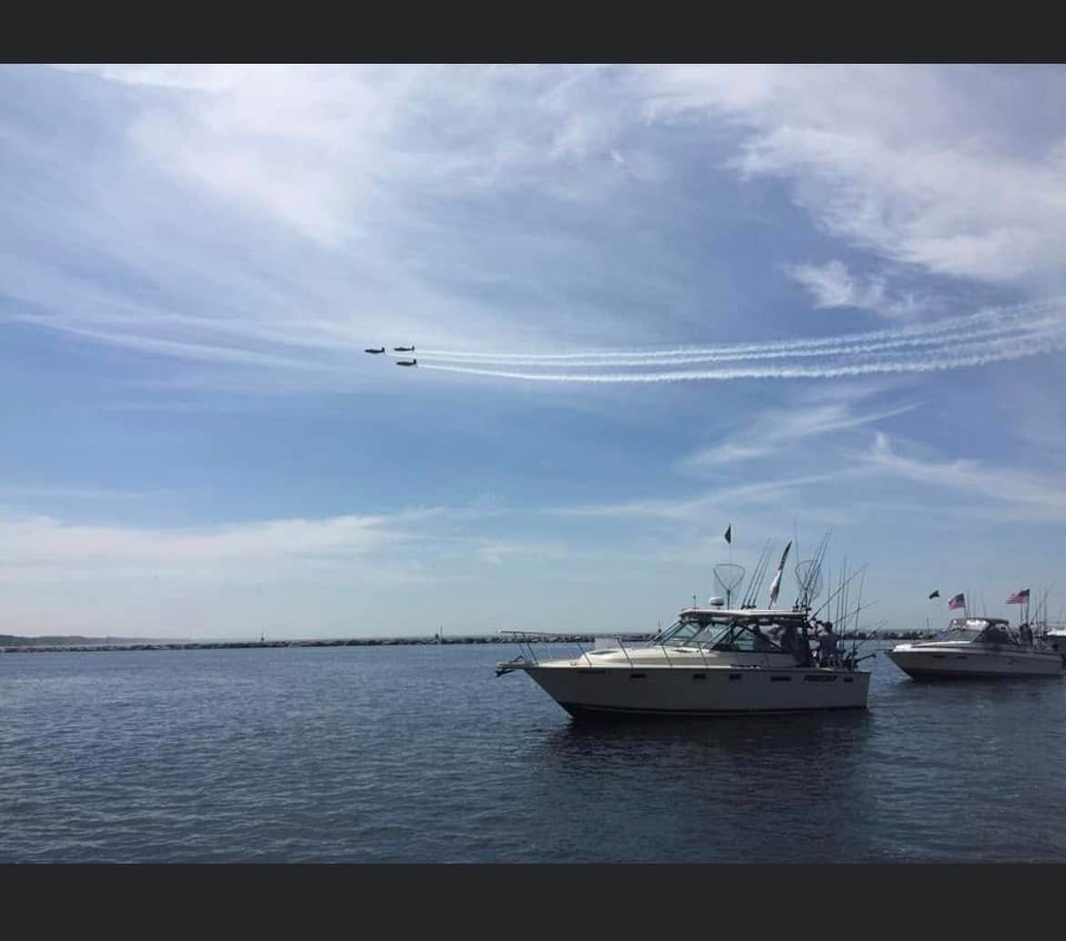 Charter fishing boats moored in Muskegon waters with military aircraft passing overhead